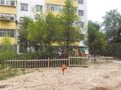 9號(hào)樓前小區(qū)綠地空置，被居民圍起柵欄圈占種菜。 本報(bào)記者    張艷麗    攝